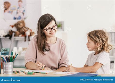 Smiling Language Tutor Working With A Little Boy Drawing With C Stock