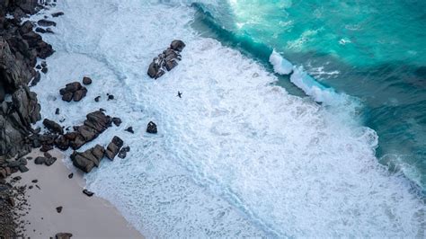 2560x1440 Brown Rocks On White Sand Beach 5k 1440p Resolution Hd 4k