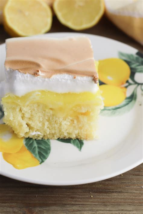 A Piece Of Cake On A Plate With Lemons In The Background