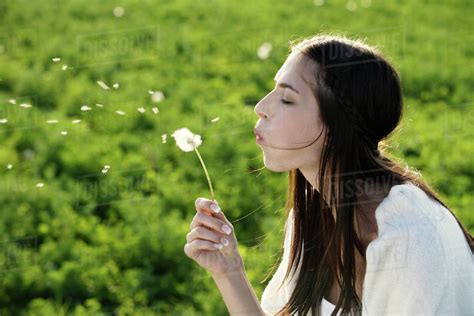 Young Woman Blowing Dandelion Stock Photo Dissolve