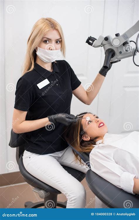 Young Female Dentist With Beautiful Woman Patient During Treatment With