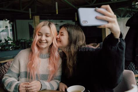 Cheerful Young Lesbian Couple Selfie Using Mobile Phone At A Coffee
