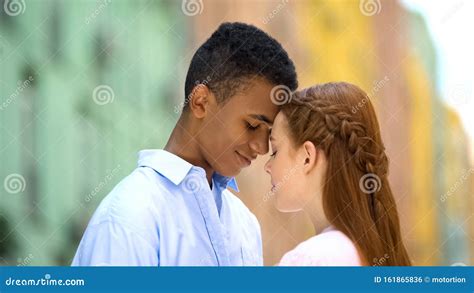 Multiethnic Teen Couple Touching Foreheads Looking Into Eyes With Love