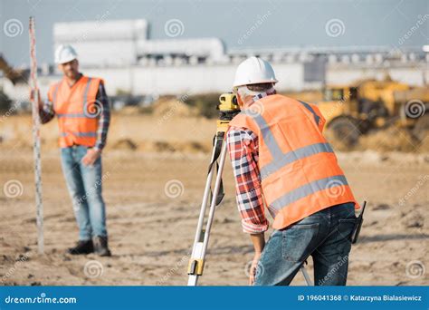 Road Construction Workers Using Measuring Device On The Field Stock