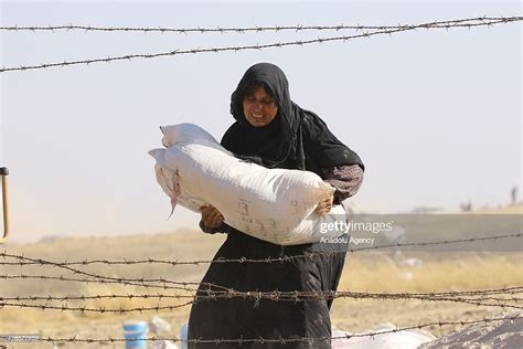 A Syrian Woman Carries Her Belongings As They Cross Into Turkey From