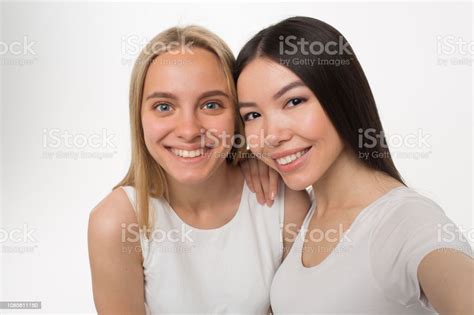 picture of brunette and blonde smiling they pose asian model hold camera isolated on white