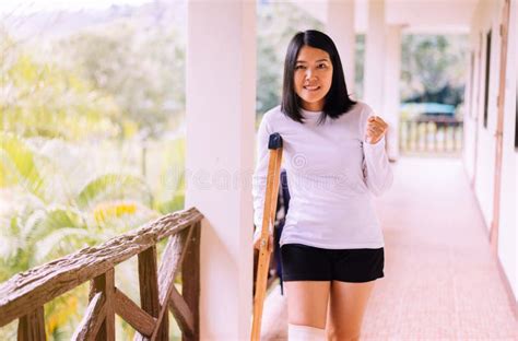 Asian Woman Patient Using Crutches And Broken Legs For Walking At