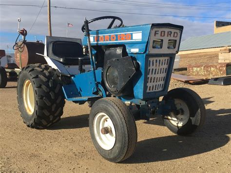 A Blue Tractor Parked On Top Of A Dirt Field