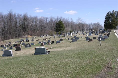 Many Headstones Are On The Grass In A Cemetery