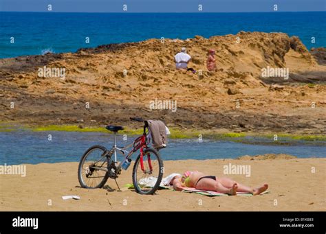 Crete Beach Holiday Woman Sunbathing On Beach At Malia On The Greek