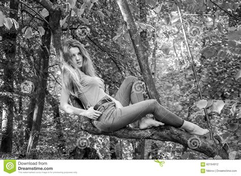 Young Beautiful Girl Model Of European Appearance With Long Hair In A Shirt And Jeans Sitting On