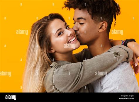 Image Of Happy Cute Young Loving Couple Posing Isolated Over Yellow Background Hugging Kissing