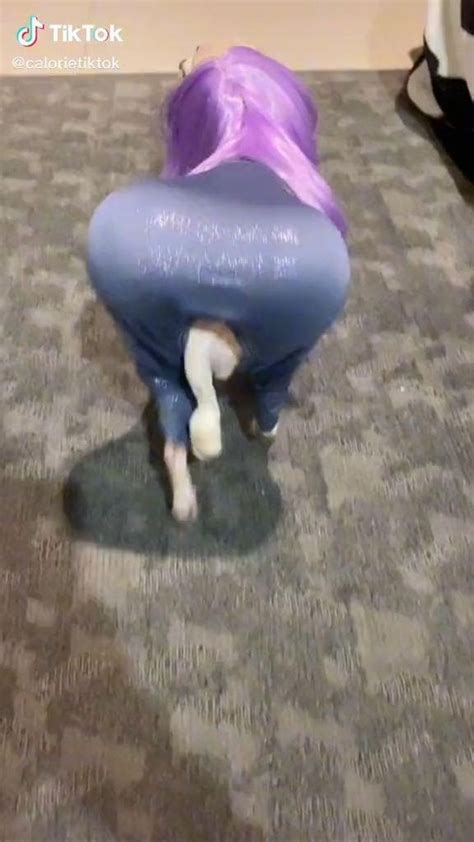 A Woman With Purple Hair Is Bending Over On The Floor