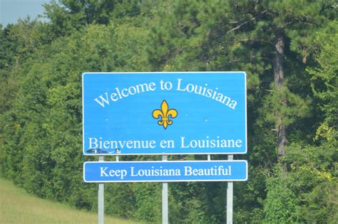 A Welcome Sign To The Town Of Louisiana In Front Of Some Trees