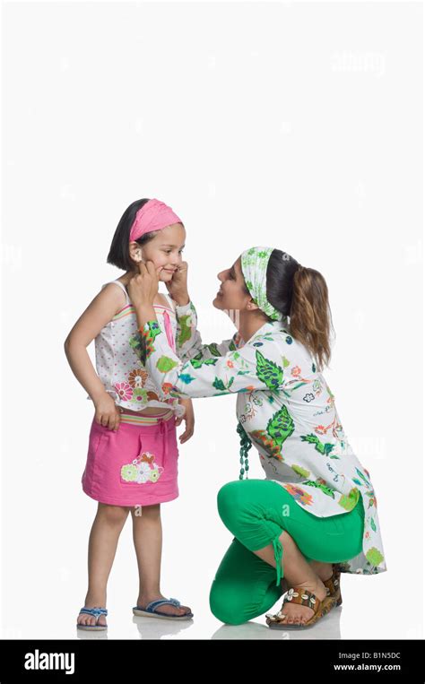 Side Profile Of A Young Woman Pinching Her Daughters Cheek Stock Photo