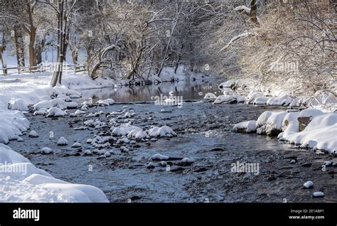 Snowy Winter Landscape Of Creek And Trees Covered In Snow After