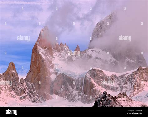 The Peak Of Mount Fitzroy At Dawn With Mist Pink Clouds And Blue Sky