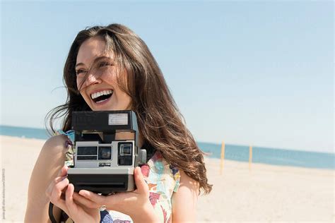 woman with polaroid camera at the beach by stocksy contributor jamie grill atlas stocksy