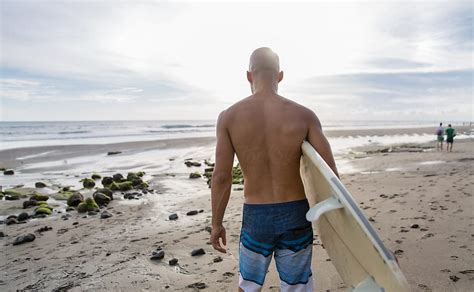 Surfer Walking To The Ocean With His Surfboard By Stocksy Contributor Jovo Jovanovic Stocksy