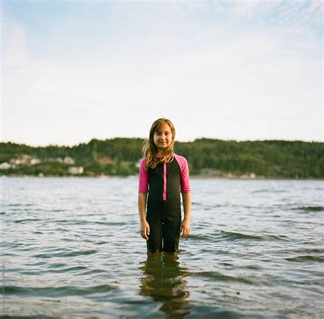 Cute Babe Girl Standing In Water With A Wet Suit By Stocksy Contributor Jakob Lagerstedt