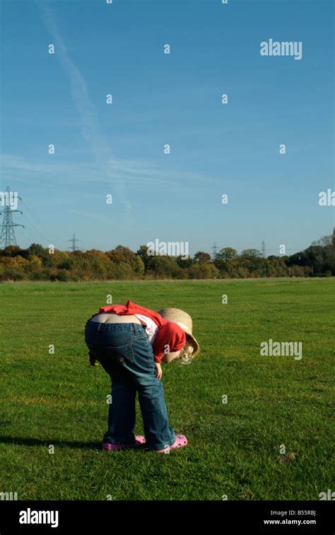 Little Girl Bending Down In The Countryside Stock Photo Alamy
