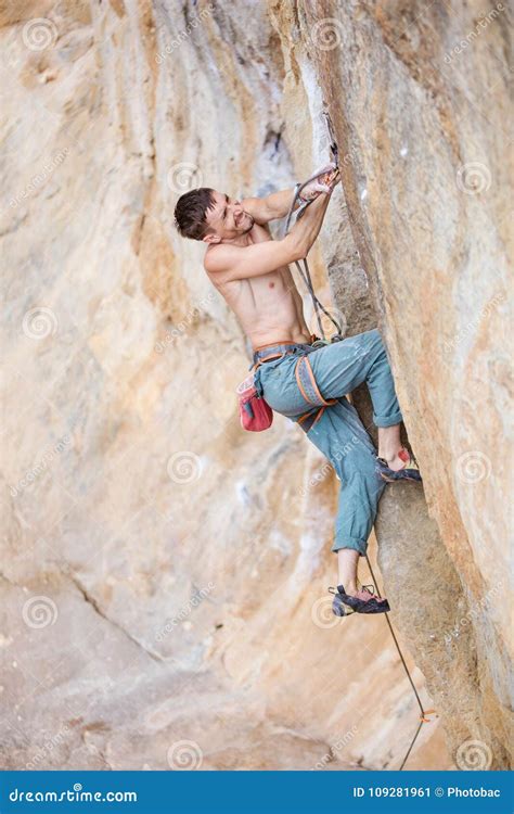 Rock Climber Clipping Rope While Climbing Challenging Route Stock Image