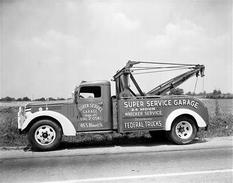 A Black And White Photo Of A Truck With A Crane On Its Back