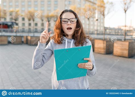 smart girl with glasses looking at the clip board and showing index finger up attention idea