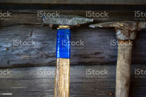 Various Hammers And Sledgehammers On The Wall With Wooden Handles Stock