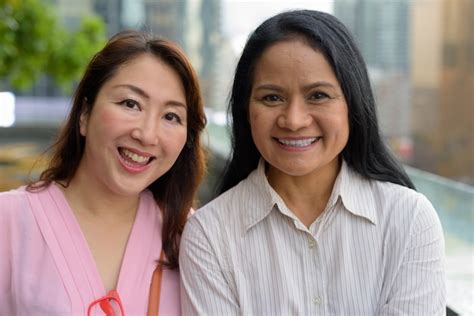 Deux Femmes Asiatiques Matures Ensemble Contre Vue Sur La Ville Photo