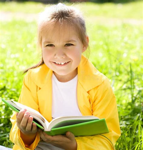 Little Girl Is Reading A Book Outdoors Stock Photo Image Of Child