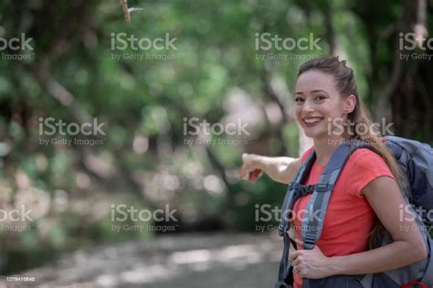 Woman Who Is Hiking Smiles While Pointing Ahead Stock Photo Download
