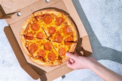 Premium Photo Closeup Of People Hands Taking Slices Of Pepperoni Pizza