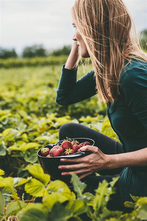 Woman Picking Strawberries In A Field By Stocksy Contributor Lior