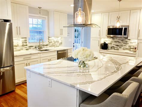 White kitchen with cambria quartz countertop. White shaker kitchen cabinets, white and gray Quartz from ...