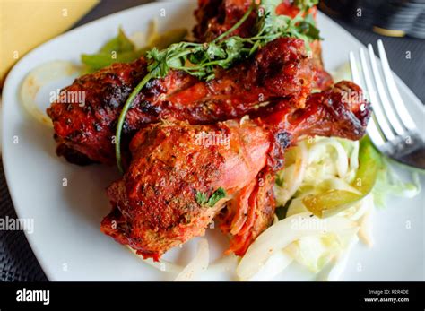 Indian Cuisine Spicy Tandoori Chicken With Cilantro Garnish Stock Photo