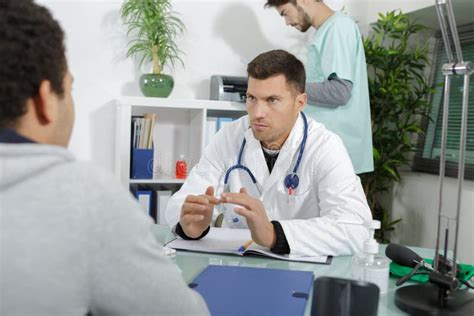 Doctors Consulting Young Man In Hospital Stock Image Image Of Patient