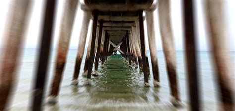 Blurred Shot Of The Underneath Of A Wooden Pier On The Beach Stock