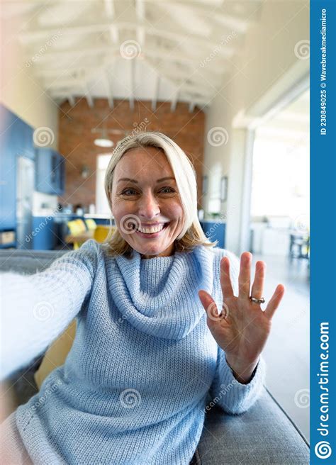 Happy Senior Caucasian Woman In Living Room Sitting On Sofa Making Video Call Stock Image