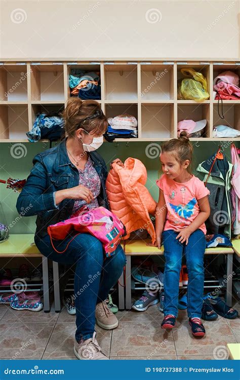 Child Changing Clothes In Changing Room In Nursery School Stock Photo