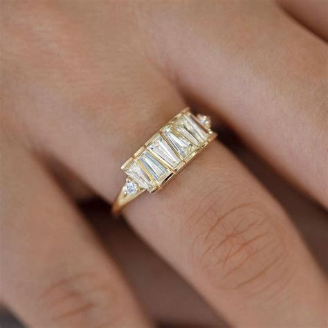 A Woman S Hand Wearing A Gold Ring With Three Baguettes