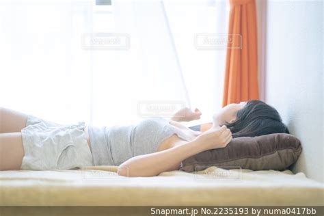 ベットの上で寝転がる女性の写真・画像素材[2235193] Snapmart（スナップマート）