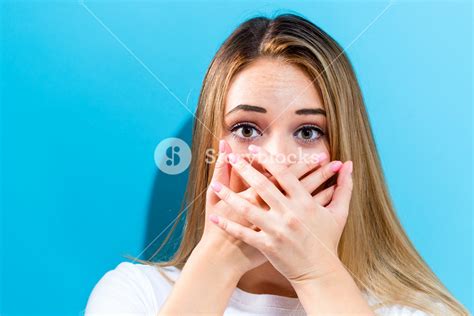 Young Woman Covering Her Mouth On A Blue Background Royalty Free Stock Image Storyblocks