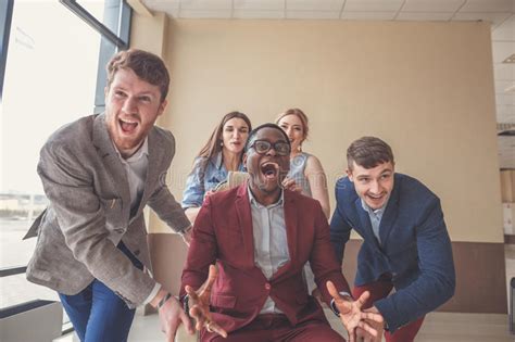 Positive Colleagues Having Fun With Office Chairs Stock Photo Image