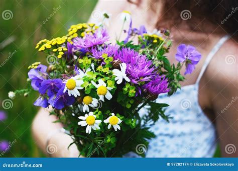 Girl With Bouquet Of Colorful Flowers In Summer Field Stock Photo