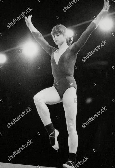 An Old Photo Of A Woman On The Balance Beam In A Gymnastics Competition