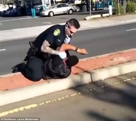 outrage as cop is caught on camera punching unarmed man and threatening witnesses with his gun