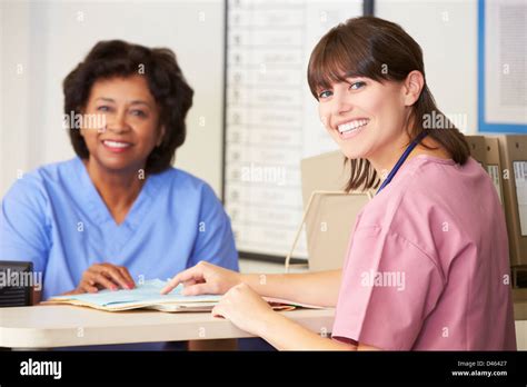 Two Nurses In Discussion At Nurses Station Stock Photo Alamy