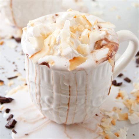 coconut hot chocolate with coconut whipped cream all topped with toasted coconut shavings hot