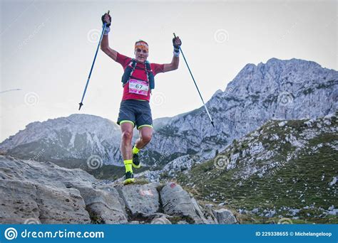 Ultra Trail Running In The Mountains A Man Raises His Hands With Poles